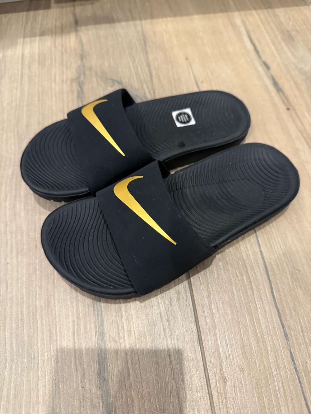 Nike Black Slides with Gold Swoosh Accent